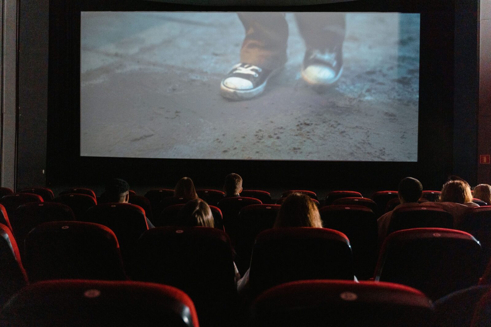 A group of people enjoying a film in a cinema with a large screen.